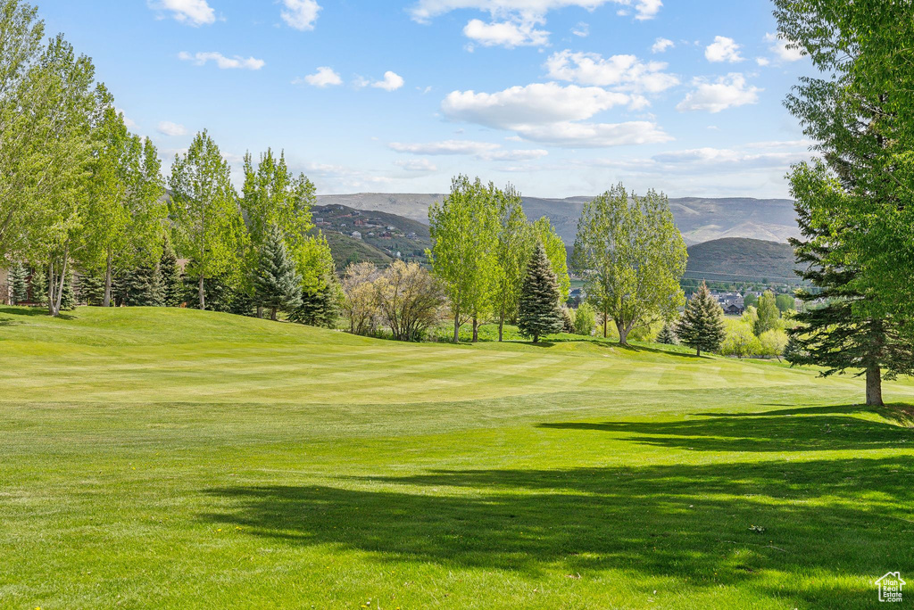 View of home\'s community with view of golf course, a mountain view, and a lawn