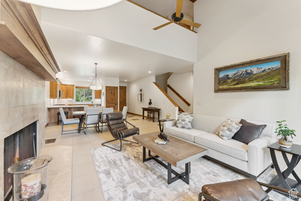 Living room with ceiling fan, light tile patterned floors, recessed lighting, and a tiled fireplace