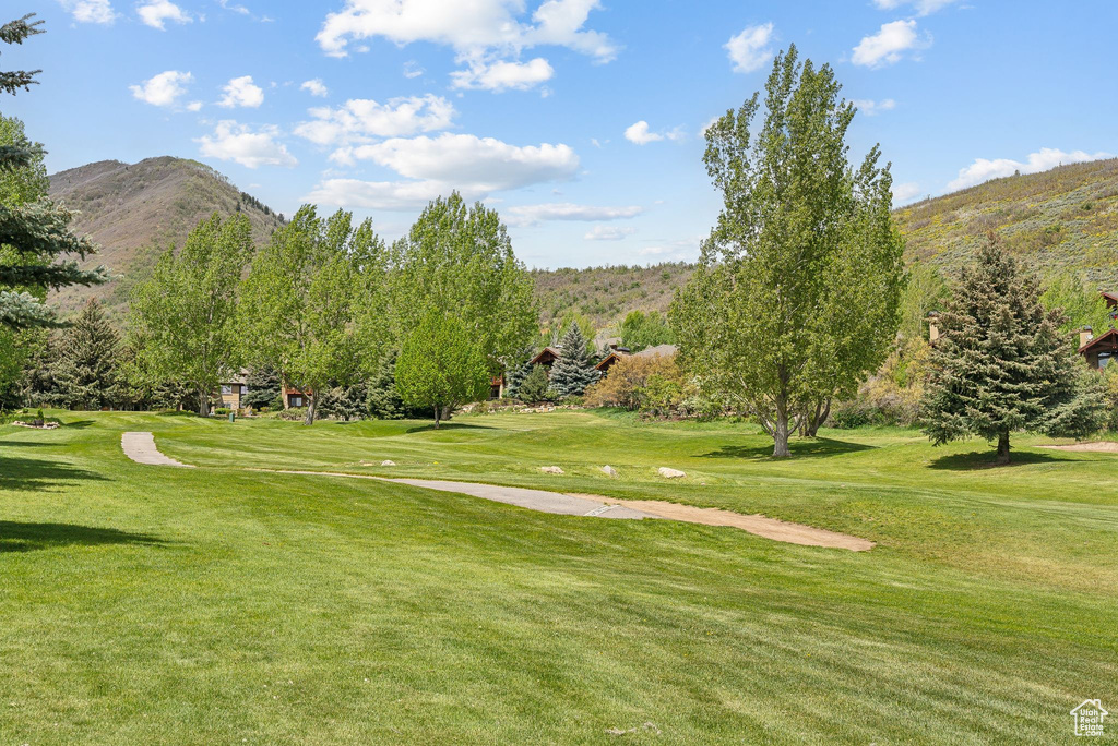 View of home\'s community with a mountain view, golf course view, and a yard