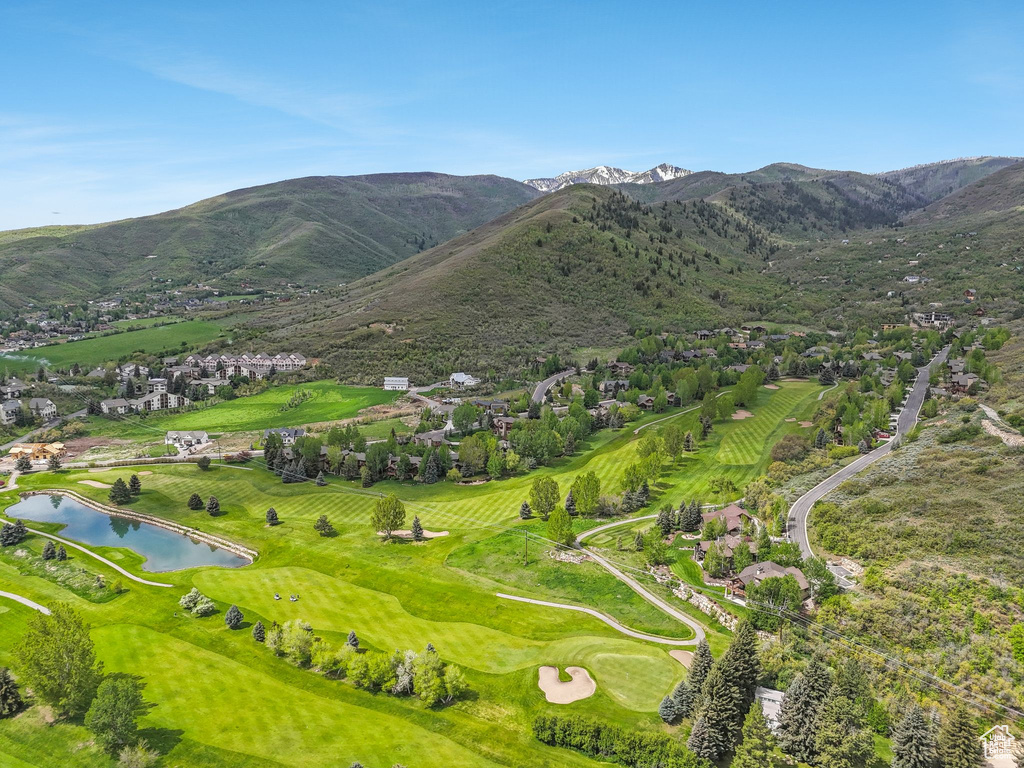 View of mountain backdrop with a nearby body of water and a golf club