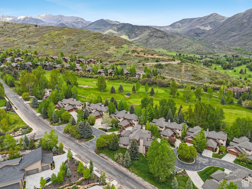Aerial overview of property\'s location featuring a mountain backdrop, nearby suburban area, and a golf club