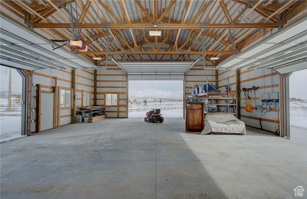 Snow covered garage featuring a garage door opener