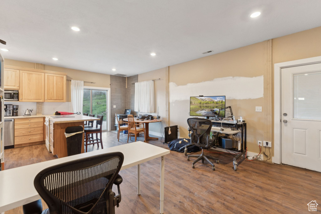 Kitchen with light brown cabinetry, appliances with stainless steel finishes, a desk, light countertops, and recessed lighting