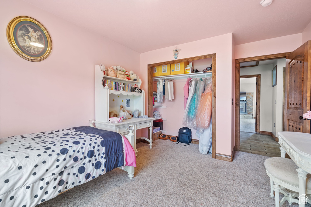 Bedroom with carpet, a closet, and baseboards