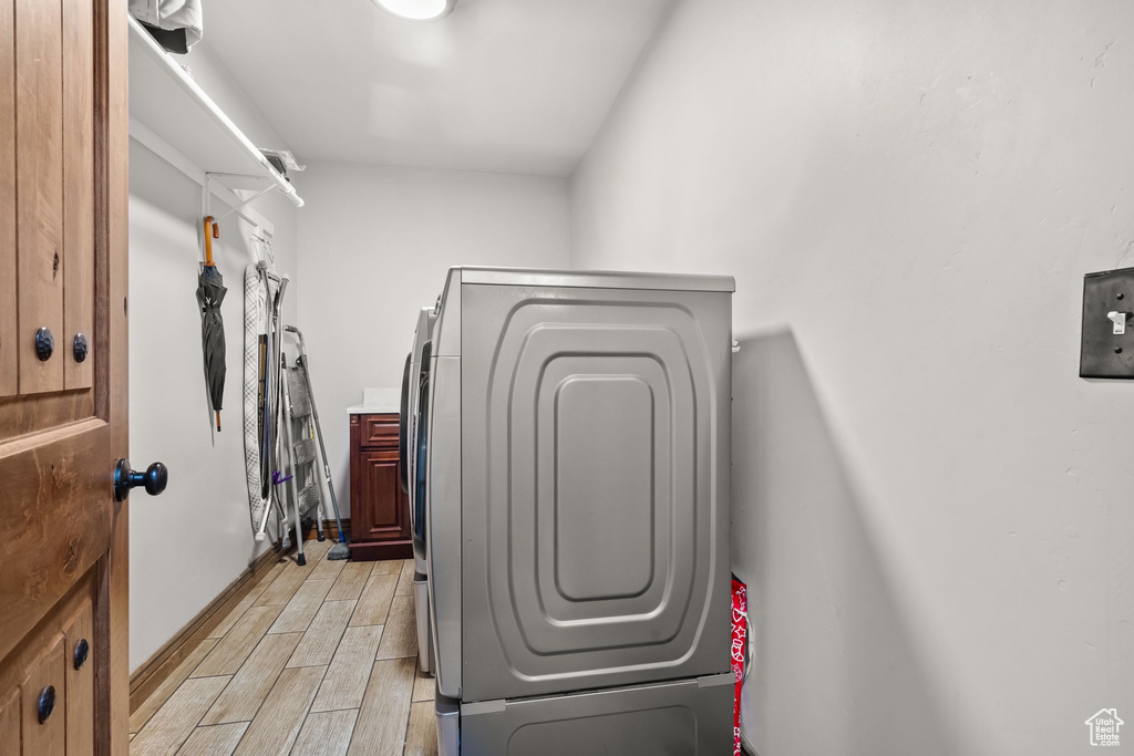 Spacious closet featuring light wood-style flooring and washing machine and dryer