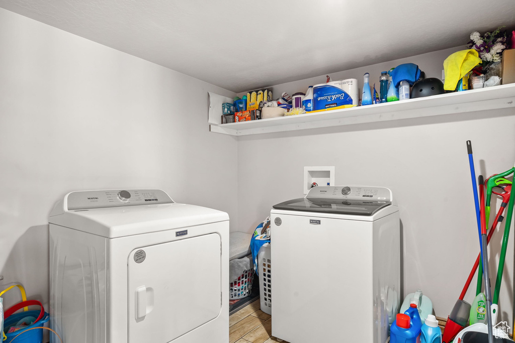 Laundry area featuring washing machine and dryer and light wood-style flooring