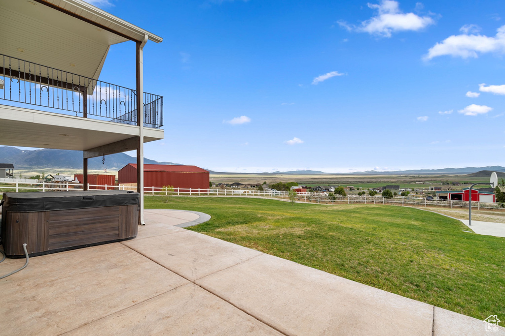 View of yard featuring a hot tub, a mountain view, a patio, and a rural view