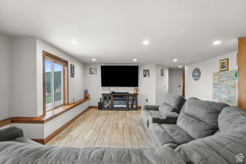 Living room with light wood-style flooring, baseboards, and recessed lighting