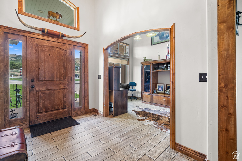 Entrance foyer featuring arched walkways, wood finish floors, and baseboards
