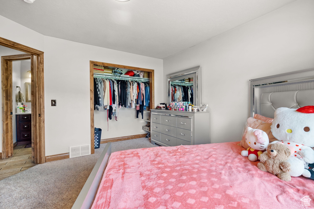 Carpeted bedroom with a closet and baseboards