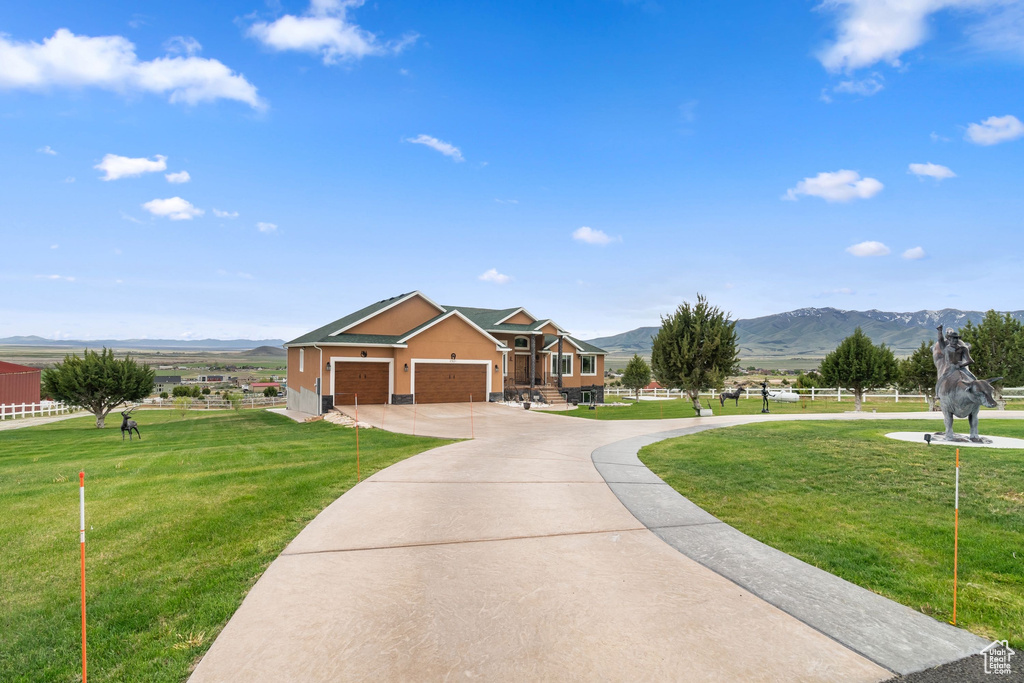 View of front facade with a mountain view, concrete driveway, and an attached garage