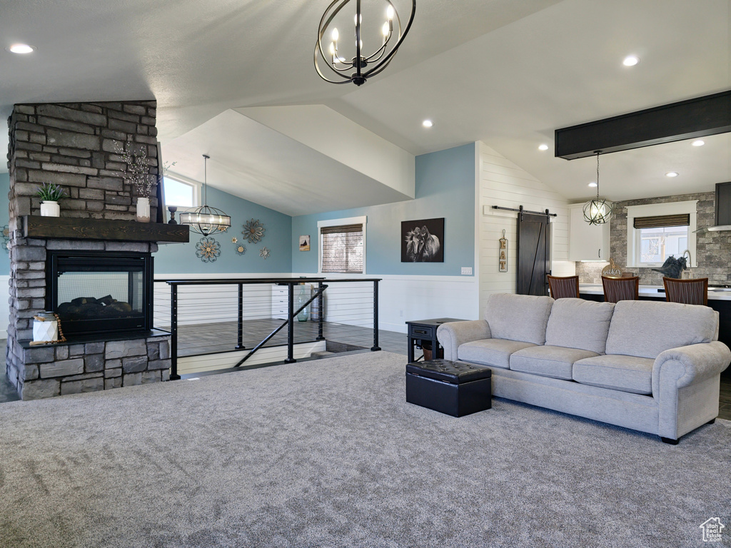Living area with a chandelier, a barn door, vaulted ceiling, carpet flooring, and recessed lighting