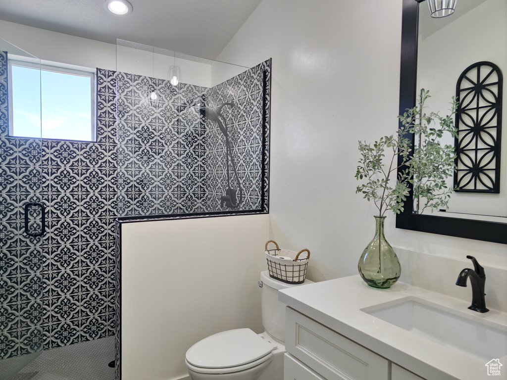 Bathroom with toilet, vanity, walk in shower, and recessed lighting