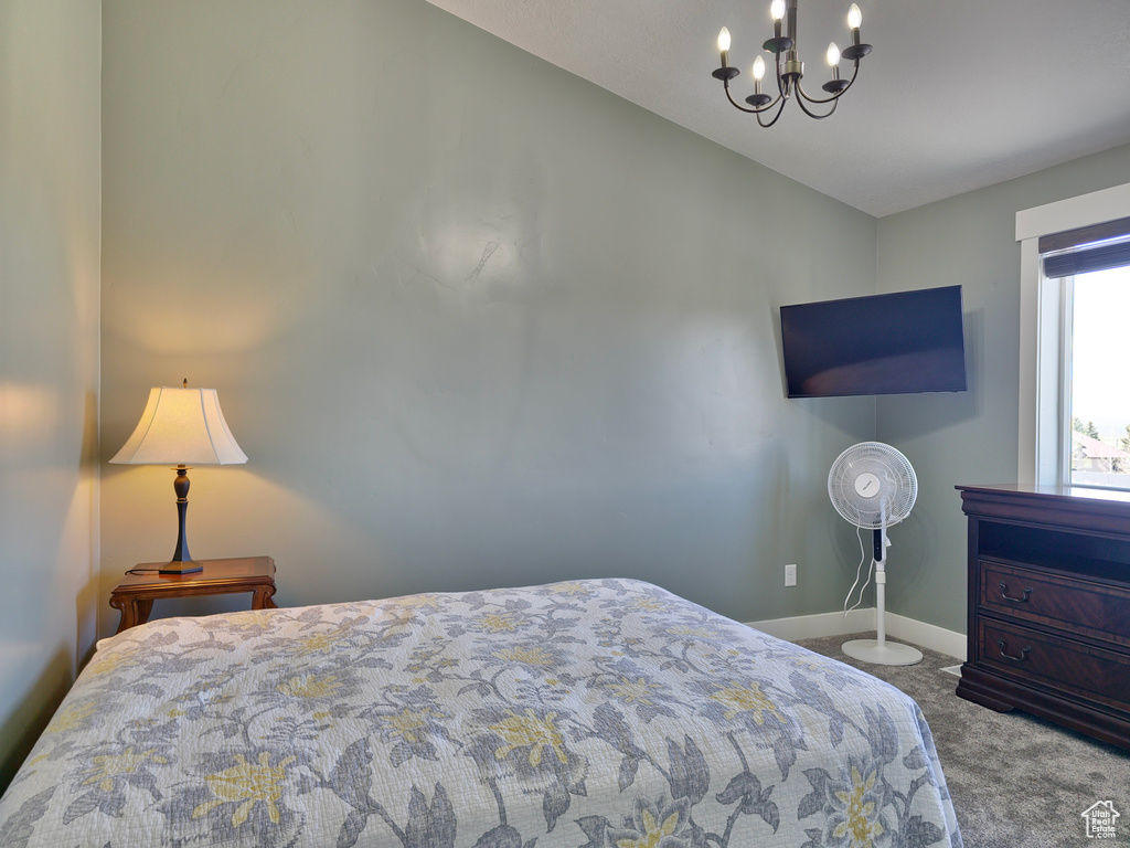 Bedroom with baseboards, a chandelier, carpet floors, and vaulted ceiling