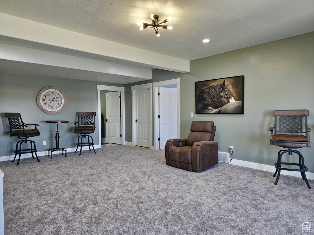 Sitting room featuring carpet flooring, baseboards, and a textured ceiling