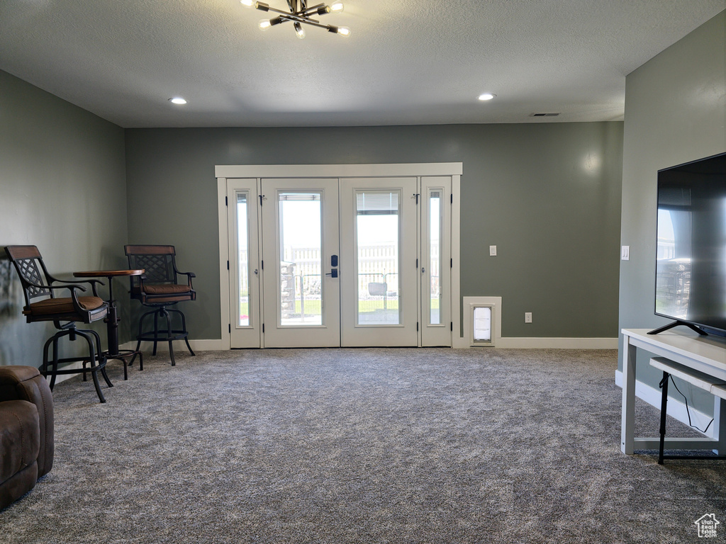 Carpeted living area with recessed lighting, baseboards, a chandelier, and a textured ceiling