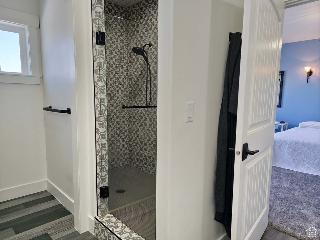 Full bathroom featuring a walk in shower, wood finished floors, and ensuite bathroom