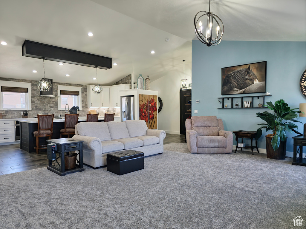 Living area featuring a chandelier, lofted ceiling, and recessed lighting