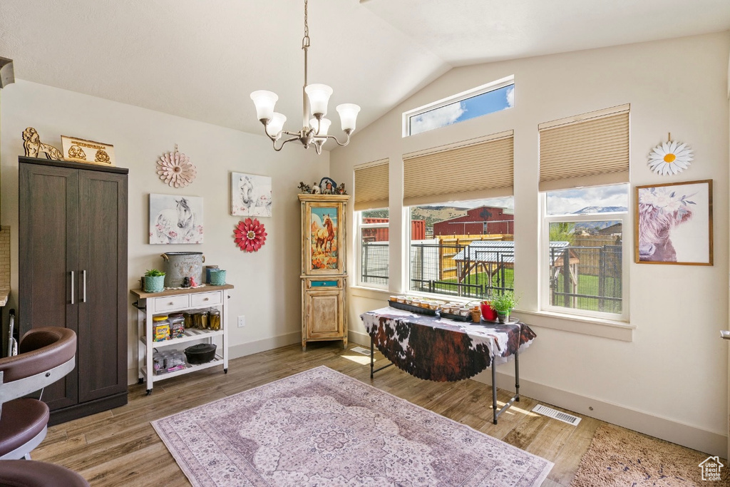 Sitting room featuring lofted ceiling, a chandelier, wood finished floors, and baseboards