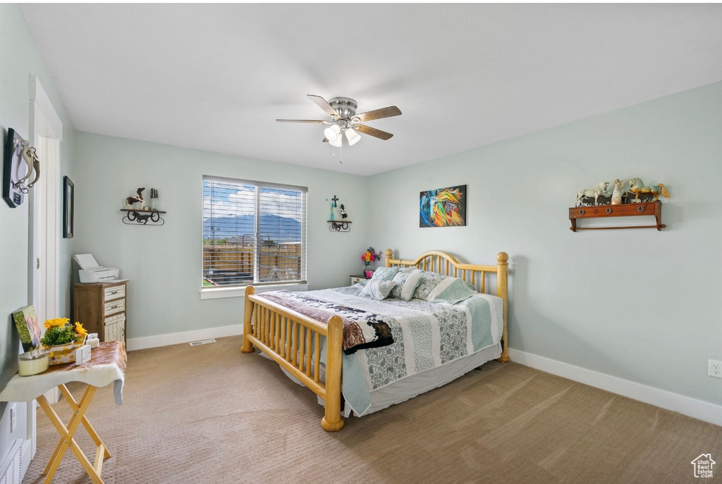 Carpeted bedroom with baseboards and ceiling fan