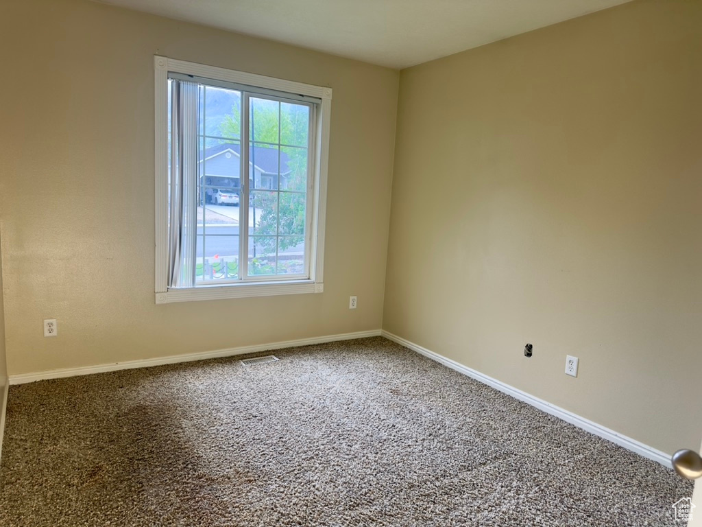 Spare room with healthy amount of natural light, carpet floors, and baseboards