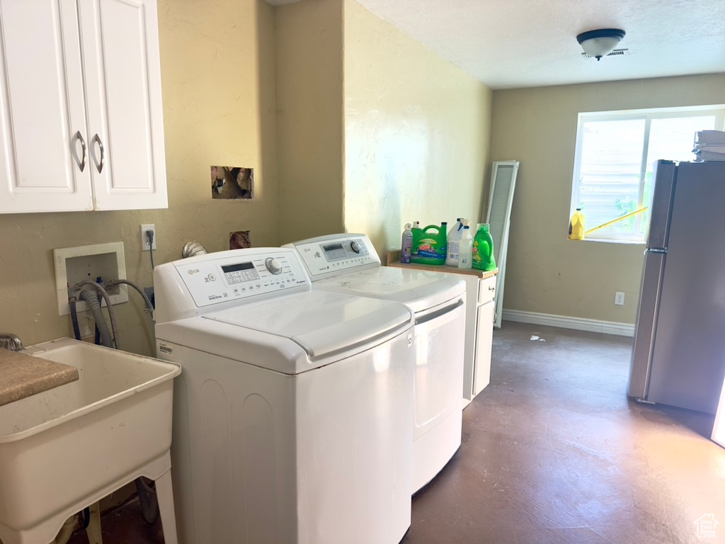 Laundry room with independent washer and dryer, cabinet space, and baseboards