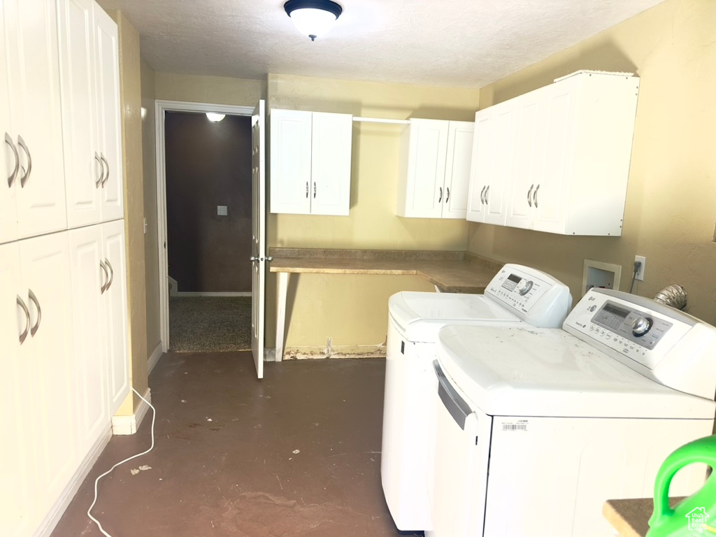 Laundry area featuring cabinet space, washer and clothes dryer, and baseboards