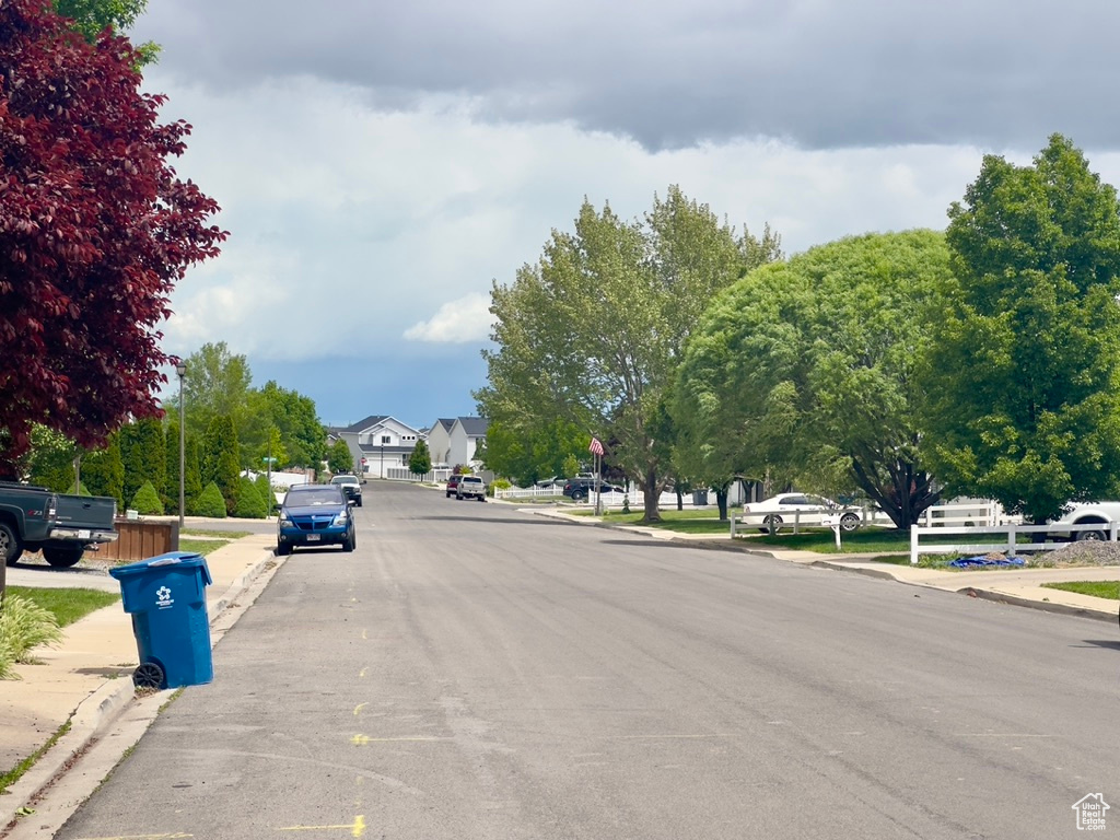 View of asphalt street featuring sidewalks and curbs