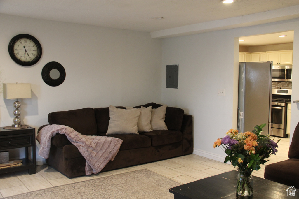 Living area with electric panel, recessed lighting, and baseboards