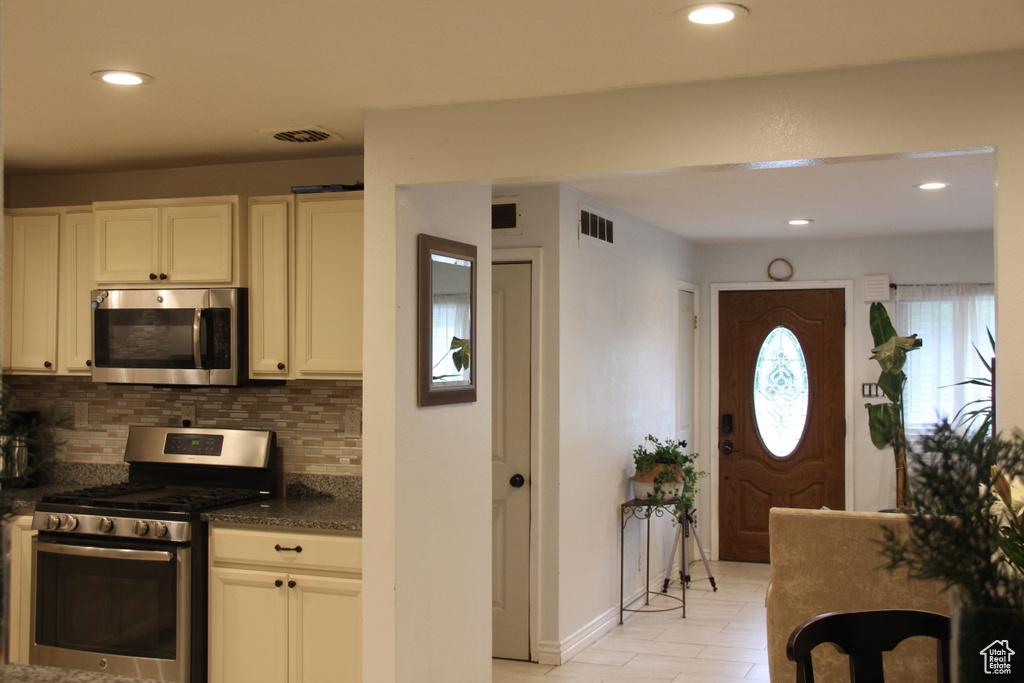 Kitchen featuring stainless steel appliances, backsplash, recessed lighting, baseboards, and white cabinets