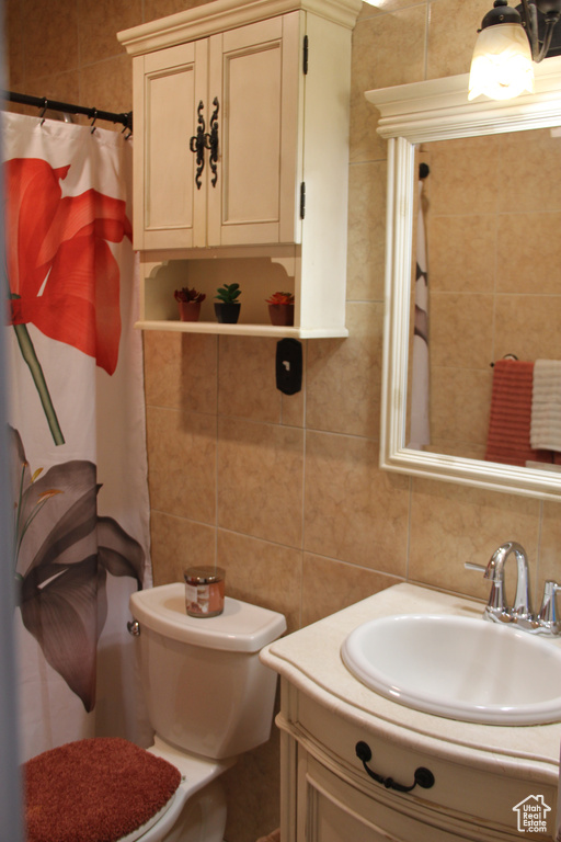 Bathroom with vanity, tile walls, decorative backsplash, a shower with shower curtain, and toilet