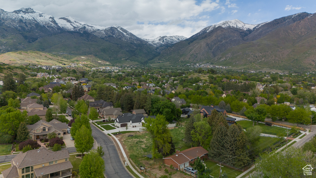 Aerial view of property and surrounding area with a mountain backdrop and nearby suburban area