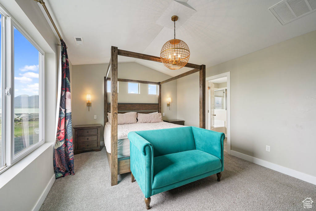 Carpeted bedroom with a chandelier, lofted ceiling, baseboards, and connected bathroom