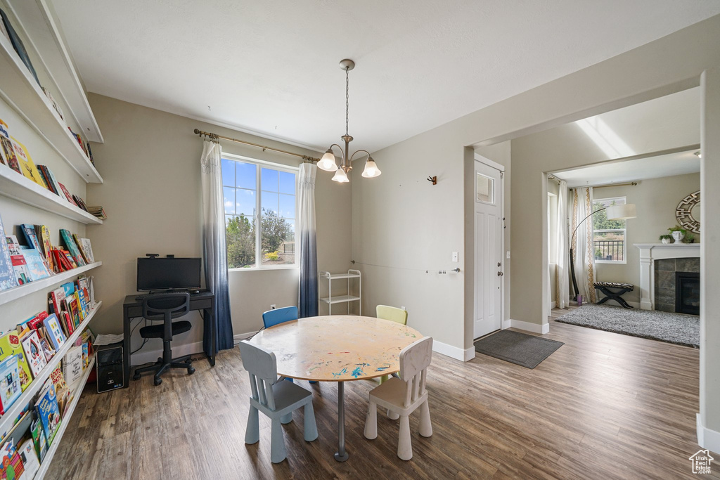 Dining space with plenty of natural light, wood finished floors, a chandelier, and baseboards