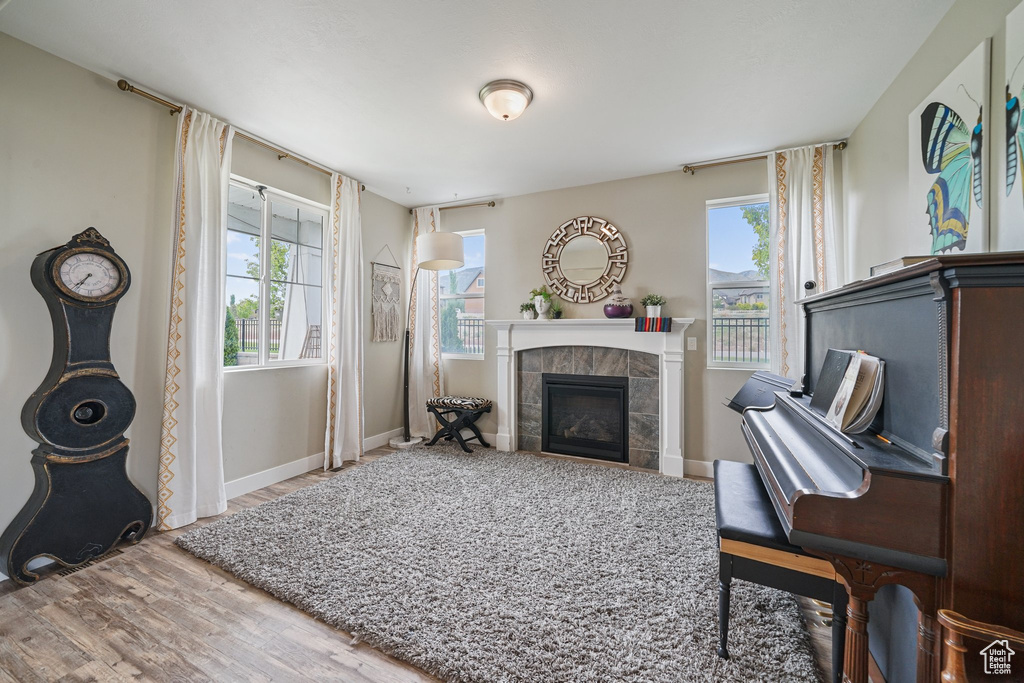 Living area with wood finished floors, a fireplace, and baseboards