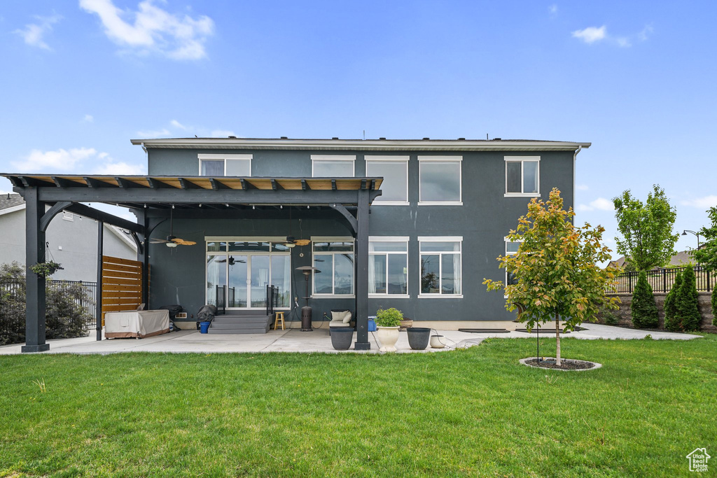 Back of house featuring stucco siding, a pergola, a patio, and a ceiling fan