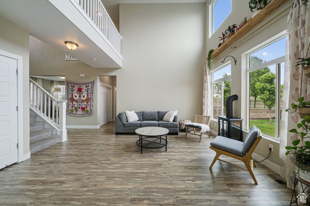 Living room featuring a towering ceiling, wood finished floors, stairs, and baseboards