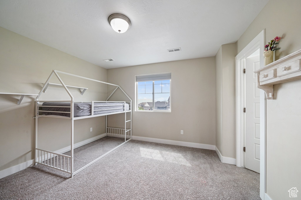 Unfurnished bedroom with carpet flooring and baseboards