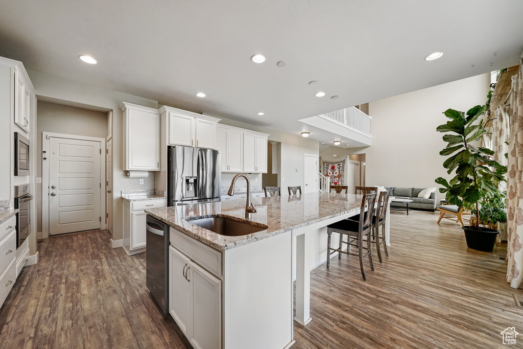 Kitchen featuring a sink, appliances with stainless steel finishes, dark wood-style flooring, recessed lighting, and a large island
