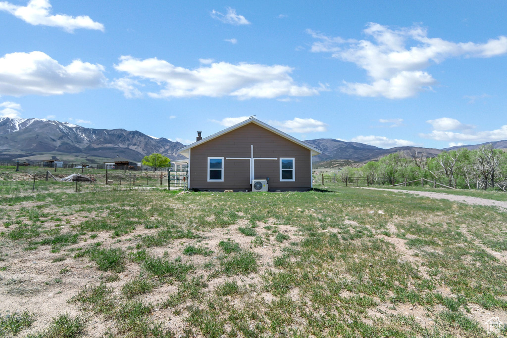 Back of house featuring a mountain view, fence, and a view of countryside