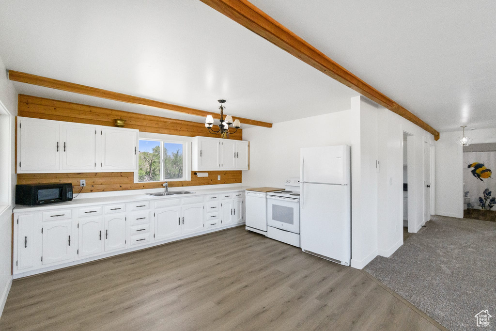 Kitchen featuring white appliances, a chandelier, a sink, white cabinetry, and light wood-style flooring