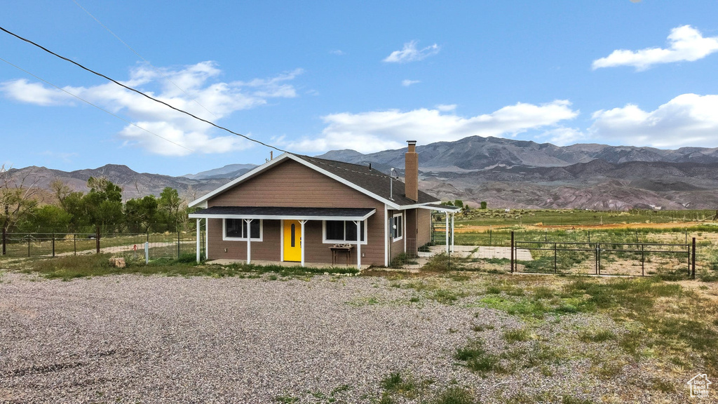 View of front of house featuring a porch, a mountain view, and fence