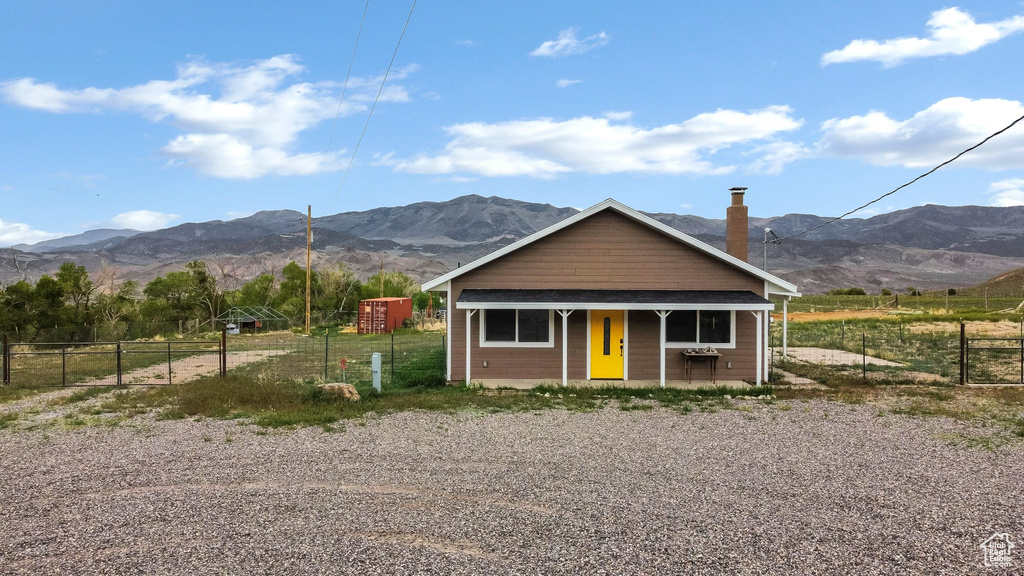 View of front of property with a mountain view, fence, and a porch