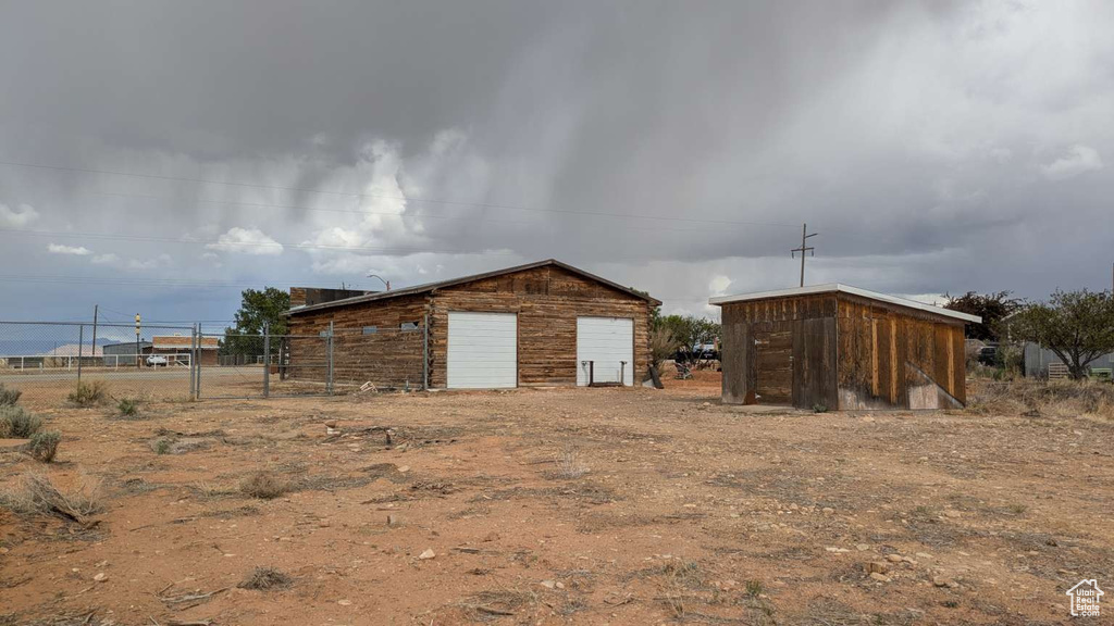 View of outdoor structure featuring fence and an outbuilding