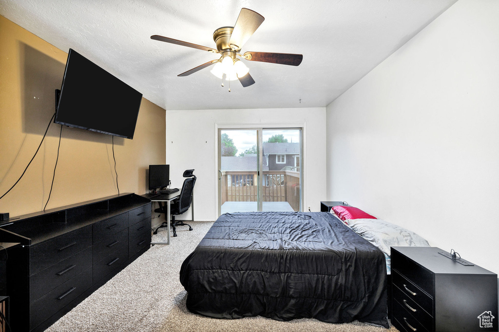 Carpeted bedroom featuring access to exterior, an office area, and ceiling fan