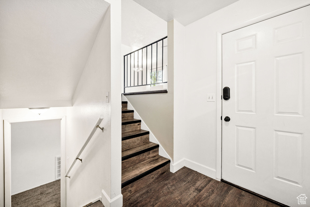 Stairs featuring wood finished floors and baseboards