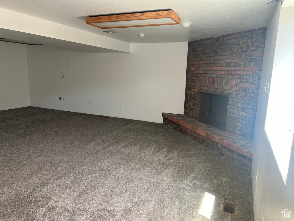 Unfurnished living room featuring carpet and a fireplace