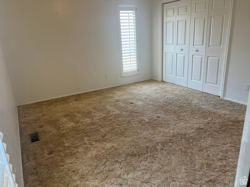Unfurnished bedroom featuring carpet floors, a closet, and baseboards
