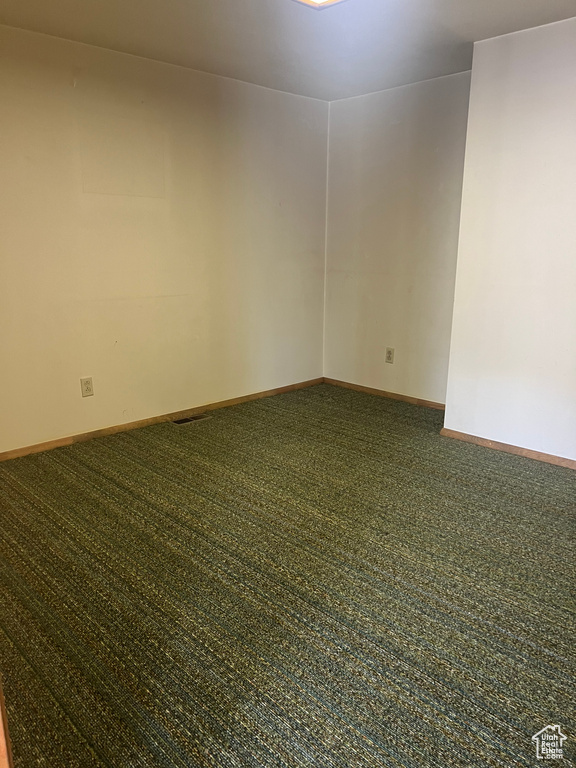 Carpeted empty room with baseboards