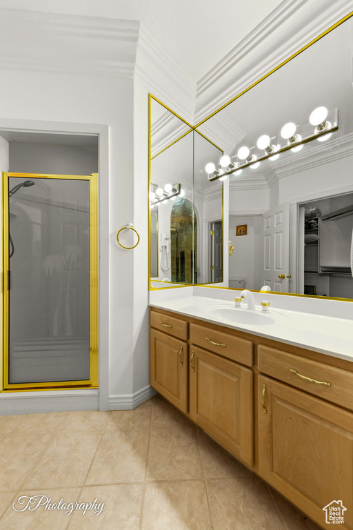 Bathroom featuring ornamental molding, a shower stall, vanity, and tile patterned floors